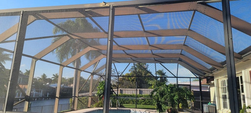 a mansard screen enclosure covering a swimming pool