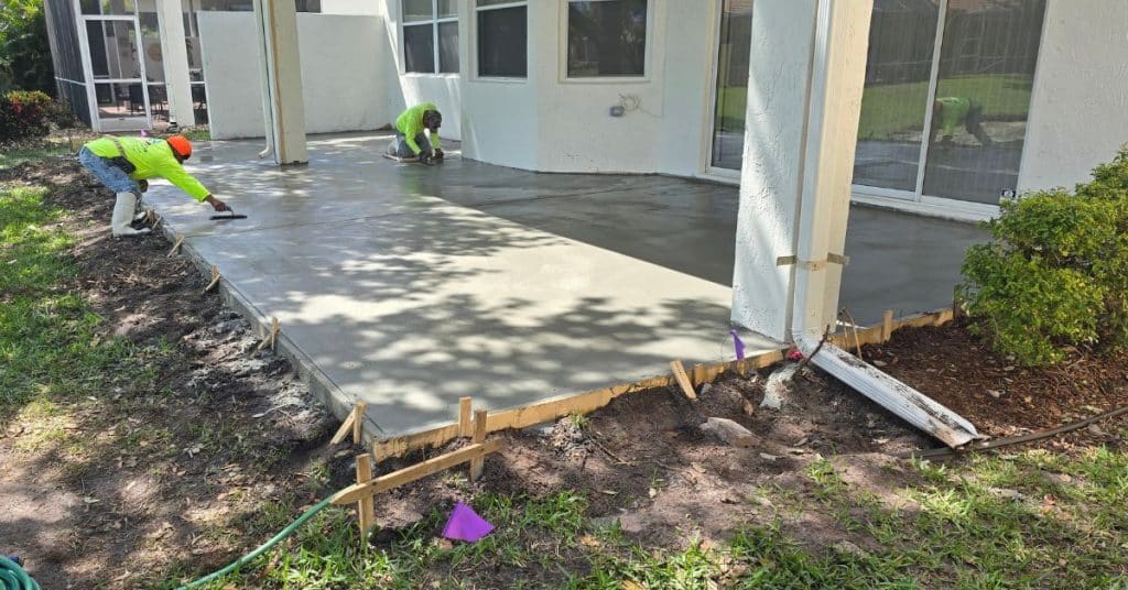 Concrete patio repair in progress behind a South Florida home by ProScreen Enclosures