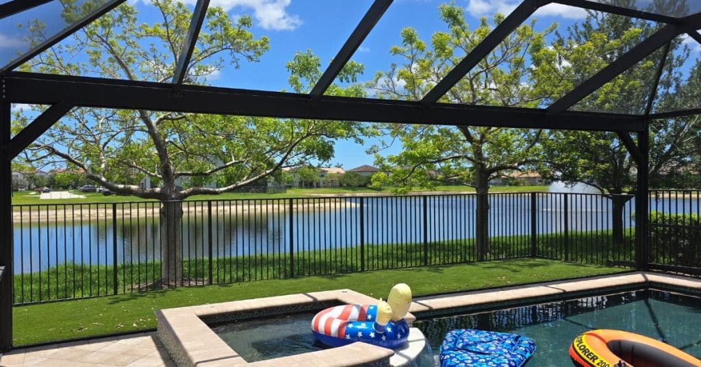 Interior view of a pool screen enclosure showing steel column framing and overhead supports