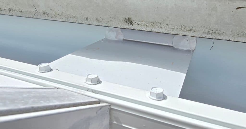 Super gutter installed along roofline to manage rainwater near a screen enclosure